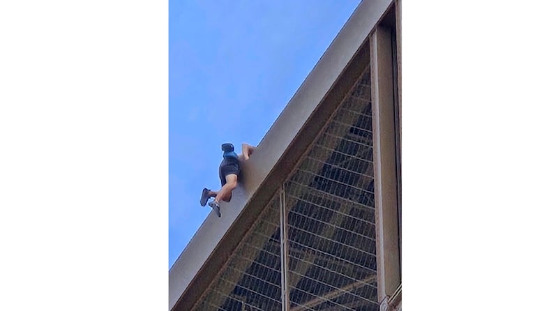 A man climbs the Eiffel Tower (Nickey Worlock via AP)