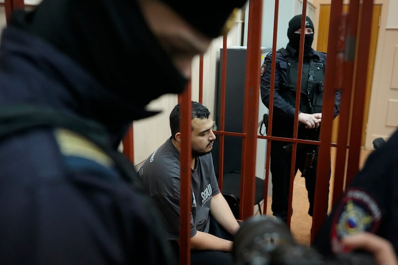 Bombing suspect Akhmadzhon Kurbonov sits in a cage in a courtroom at the Basmanny district court in Moscow (Pavel Bednyakov/AP)