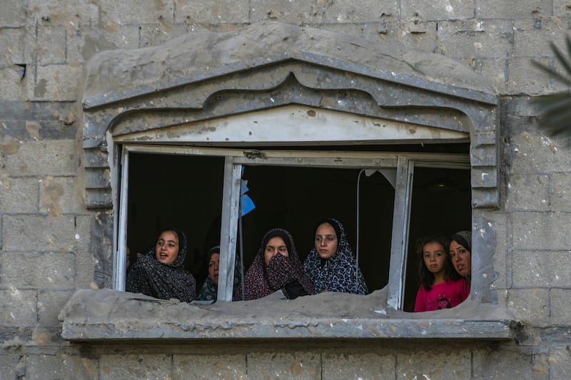 Palestinians look at the destruction after an Israeli air strike on a crowded tent camp in Muwasi in the Gaza Strip (Abdel Kareem Hana/AP)