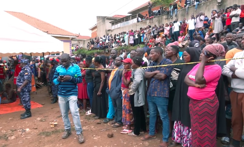 People gather at the site of a collapsed landfill in Kampala (AP)