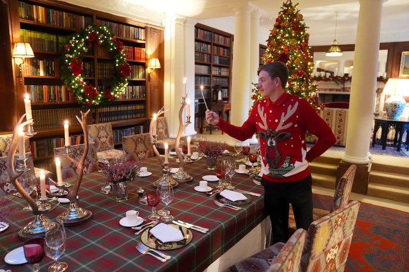 Dumfries House steward Joe Mackie lights candles on a dining table in the library