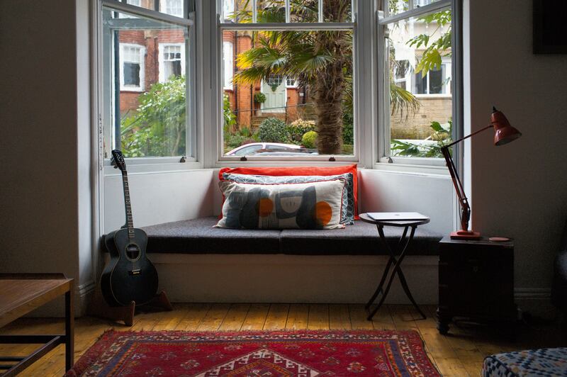 2WMHKX6 View looking out from a 1906 Edwardian House bay window with a seat and guitar