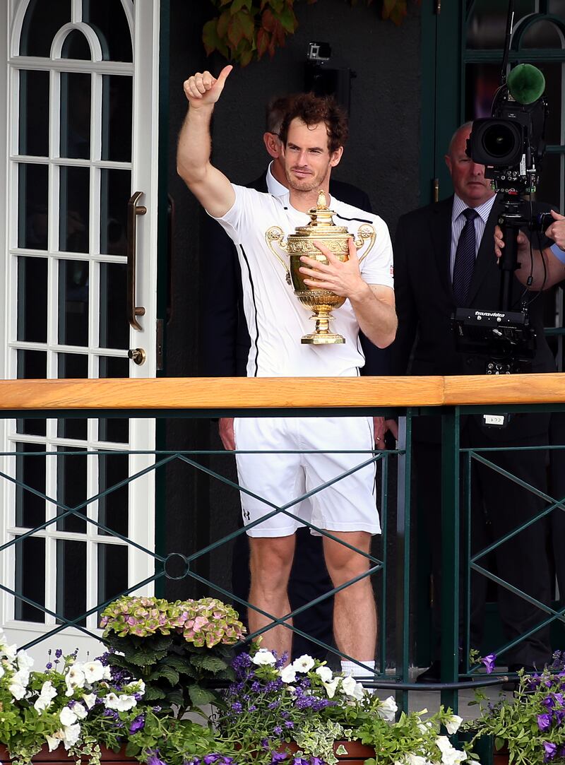 Sir Andy Murray parades the Wimbledon trophy on a centre court balcony