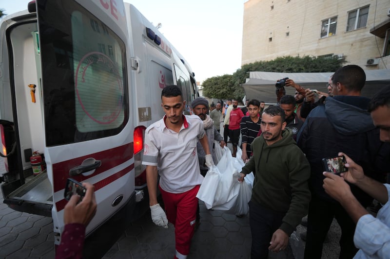 Palestinians carry the body of a person killed during an Israeli bombardment (Abdel Kareem Hana/AP)