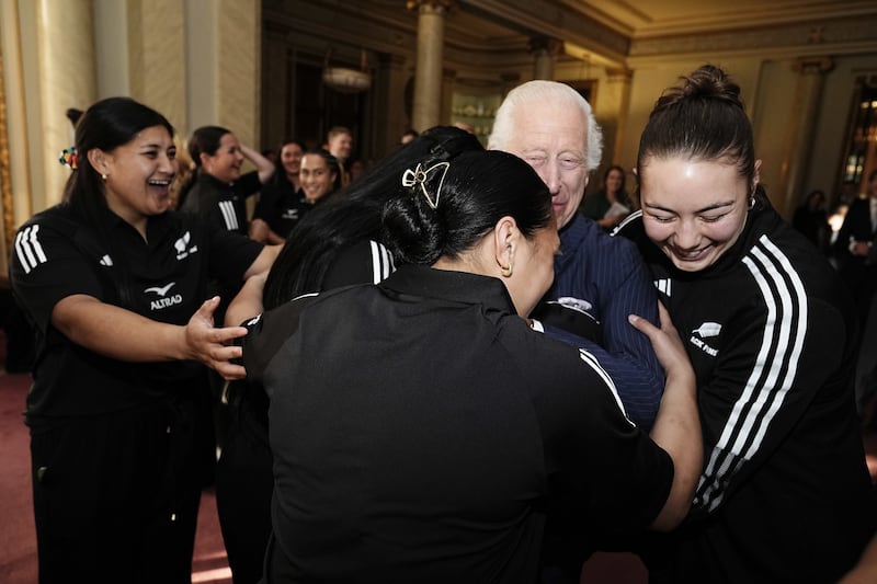 Charles is hugged by the rugby players