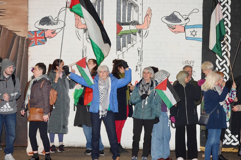 People gather at the Palestine Murals on the Falls Road following the announcement of a ceasefire in Gaza. PICTURE: MAL MCCANN