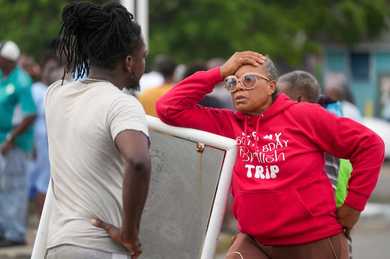 Sylvia Small, right, waits for police approval to enter the pier to check her boat’s damages due to Hurricane Beryl at the Bridgetown Fisheries in Barbados (Ricardo Mazalan/AP)