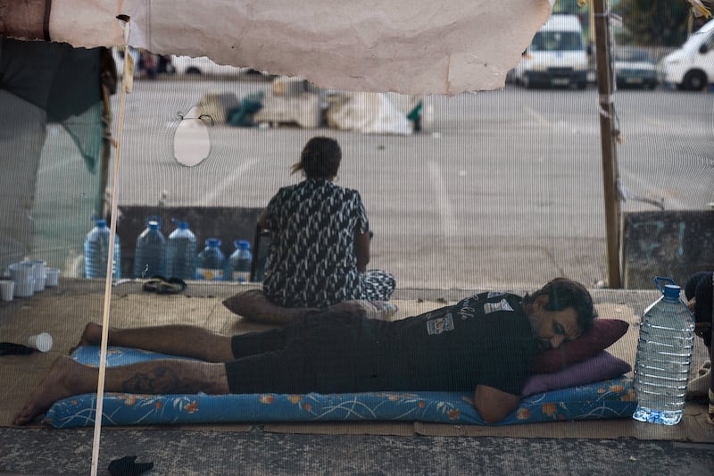 A family fleeing the Israeli airstrikes in Dahiyeh, sits in Martyrs’ square in Beirut, Lebanon (Bilal Hussein/AP)