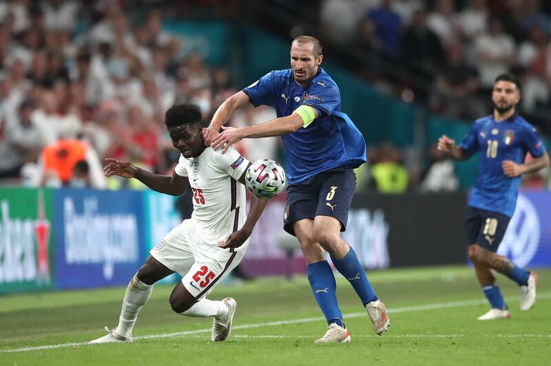 Italy’s Giorgio Chiellini pulls back Bukayo Saka during the Euro 2020 final .