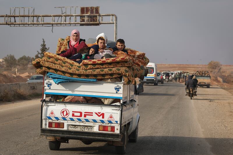 Residents flee the fighting in Hama carrying their belongings (Ghaith Alsayed/AP)