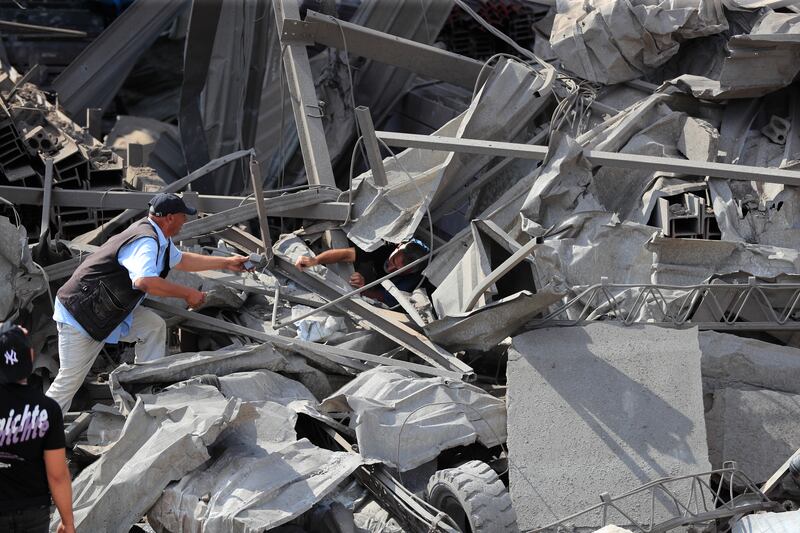 People check an industrial area destroyed by an Israeli air strike, in Wadi al-Kfour in southern Lebanon (AP Photo/Mohammed Zaatari)