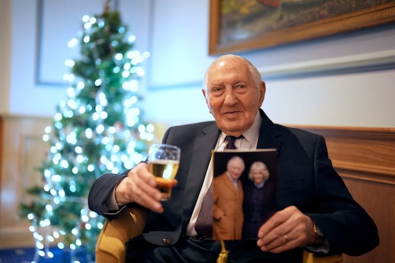 Normandy veteran Mervyn Kersh enjoys a drink as he reads his birthday card from the King during a surprise party for his 100th birthday at the Union Jack Club in London