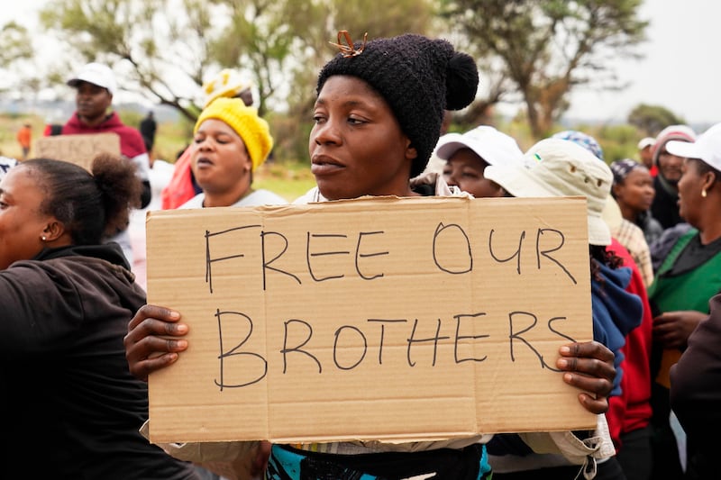 Relatives and friends protest near the mineshaft (Denis Farrell/AP)