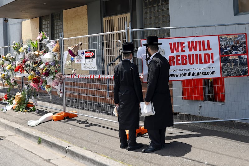 People gather outside the fire damaged Adass Israel Synagogue in Melbourne (Con Chronis/AAP Image via AP)