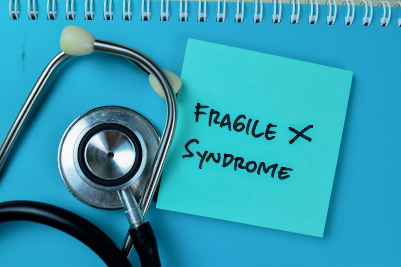 Fragile X Syndrome written on a blue sticky notes next to a stethoscope