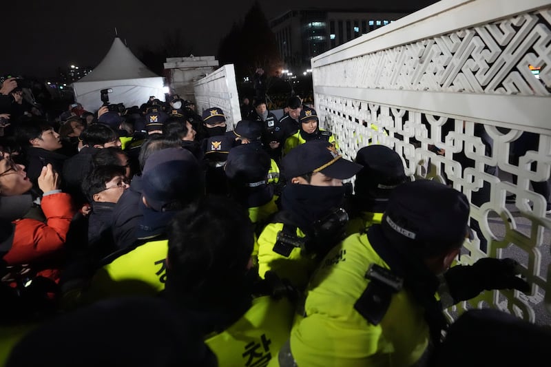 People try to enter as police officers stand guard in front of the National Assembly in Seoul, South Korea (Lee Jin-man/AP)