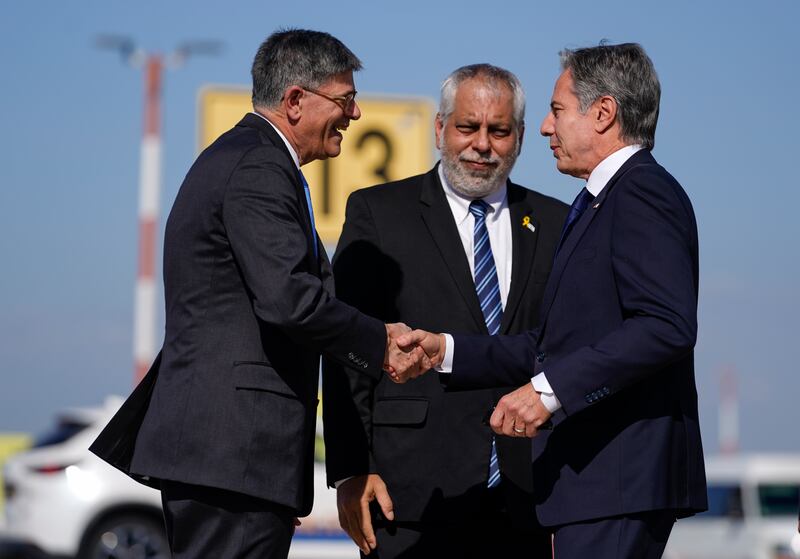 US Secretary of State Antony Blinken is welcomed by US Ambassador to Israel Jack Lew and Israeli Ministry of Foreign Affairs Deputy Director General for North America Lior Hayat (Nathan Howard/Pool/AP)