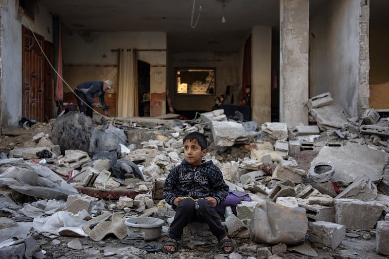 A Palestinian boy sits on the rubble of a destroyed building after an Israeli strike in Rafah, southern Gaza Strip (Fatima Shbair/AP)