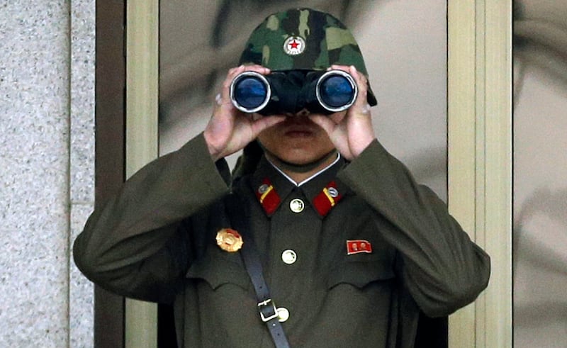 A North Korean soldier looks at the southern side through a pair of binoculars at the border village of Panmunjom (Lee Jin-man/AP)