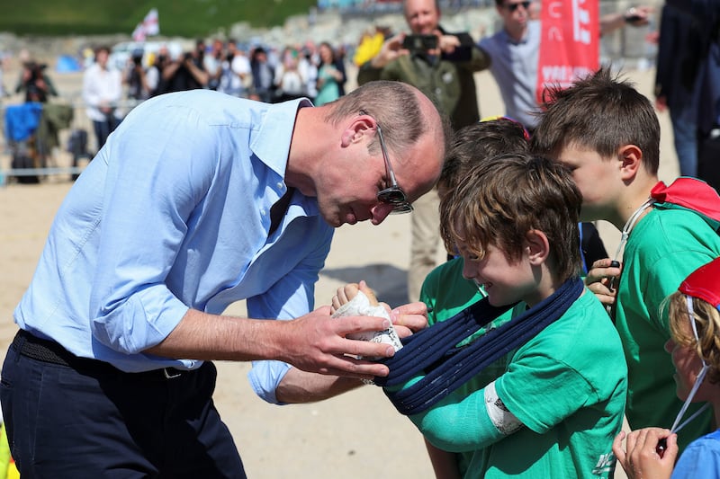 William signs the cast of Felix Kanes, a member of Holywell Bay Surf Life Saving Club