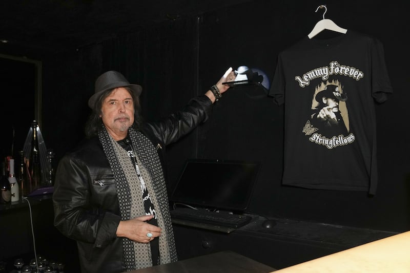 Phil Campbell next to the urn that contains part of the ashes of Lemmy from Motorhead, which is placed behind the bar at Stringfellows nightclub in London