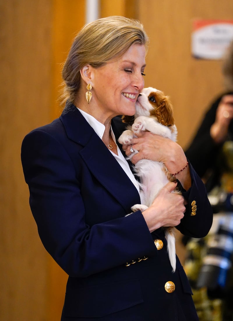 Sophie cuddles puppy Lord Louis of Spudringham during a visit to Dogs for Autism