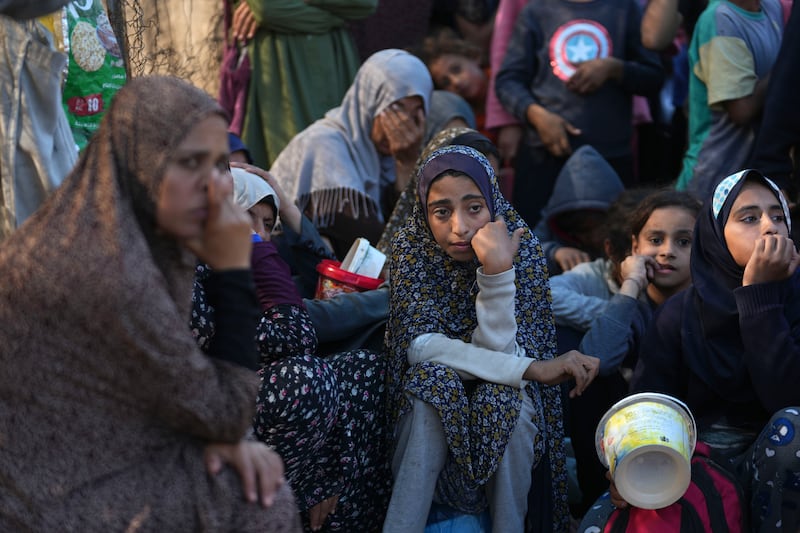 Palestinians queue for food in Deir al-Balah in the Gaza Strip (Abdel Kareem Hana/AP)