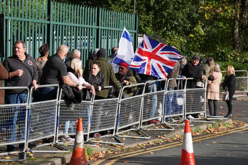 People gather outside Woolwich Crown Court, where Tommy Robinson, was due to appear after breaching a High Court order from 2021