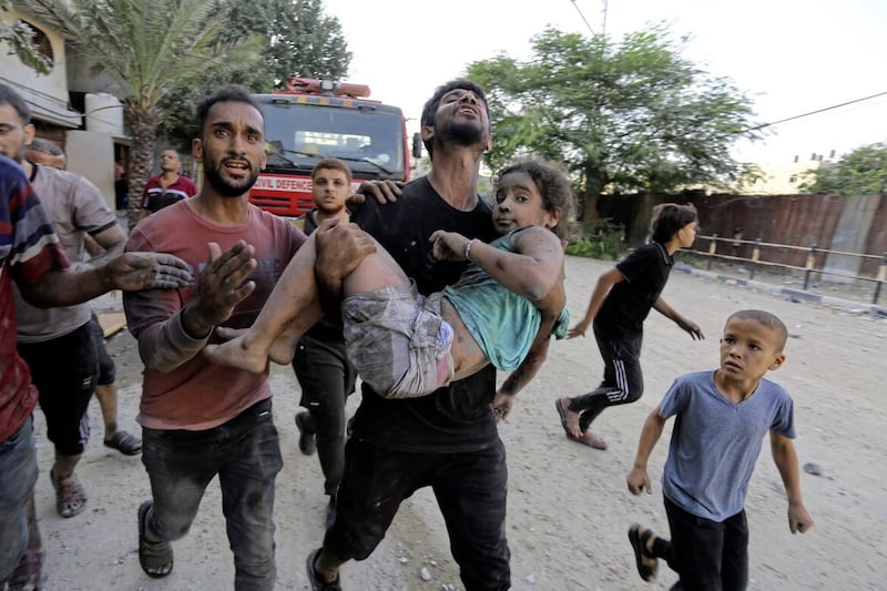 Palestinians carry a wounded girl after being rescued from under the rubble of buildings that were destroyed by Israeli airstrikes in Jabaliya refugee camp, northern Gaza Strip 