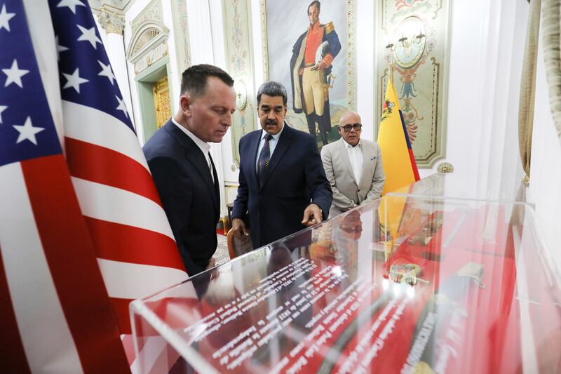 This photo released by Venezuela’s presidential press office shows Venezuelan President Nicolas Maduro, centre, with Richard Grenell, President Donald Trump’s special envoy, left, at Miraflores presidential palace in Caracas (Venezuela’s presidential press office/AP)