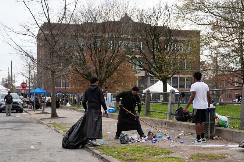 People clean up debris at the scene of a shooting at an Eid al-Fitr event in Philadelphia (Matt Rourke/AP)