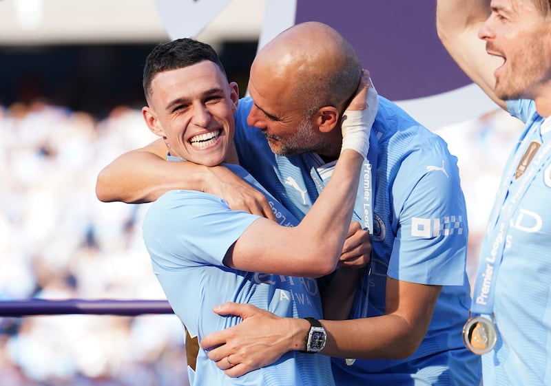 Manchester City manager Pep Guardiola celebrating with Phil Foden after winning a fourth consecutive Premier League title