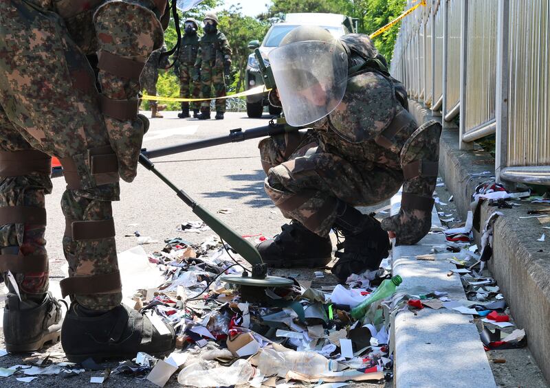 South Korean soldiers wearing protective gear check the rubbish from a balloon believed to have been sent by North Korea, in Incheon, South Korea (AP)