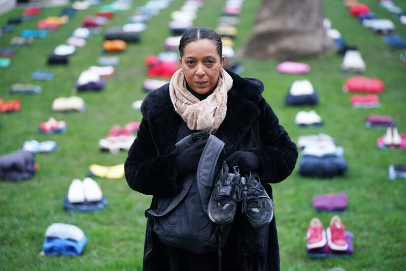 Yemi Hughes, holding clothes her son Andre Aderemi, 19, was wearing when he was stabbed to death in Croydon in 2016