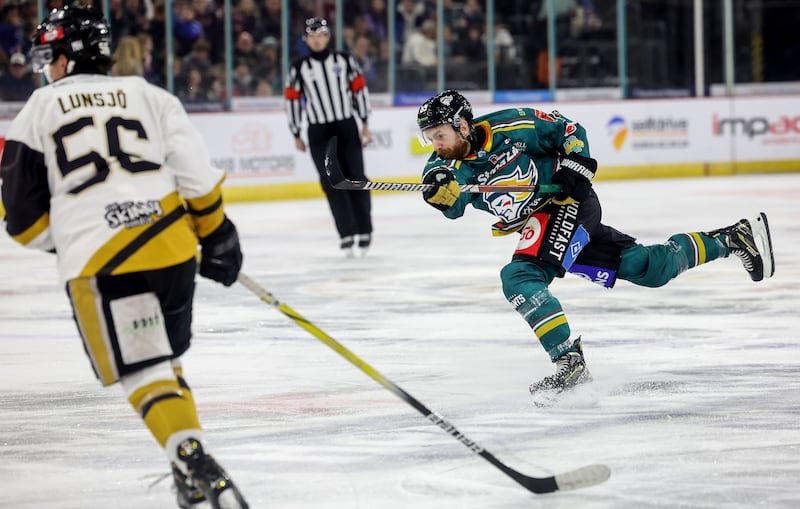 Ciaran Long shooting a puck in a Belfast Giants jersey