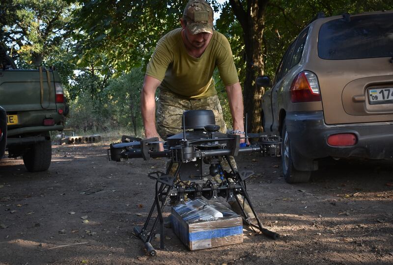 A soldier of Ukraine’s 141st separate infantry brigade loads a drone with a parcel for soldiers on a mission at the frontline in Zaporizhzhia region, Ukraine (AP Photo/Andriy Andriyenko)