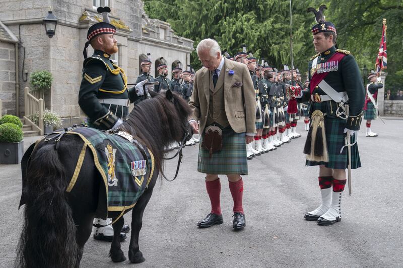 The King performing a traditional inspection of the troops outside Balmoral in August