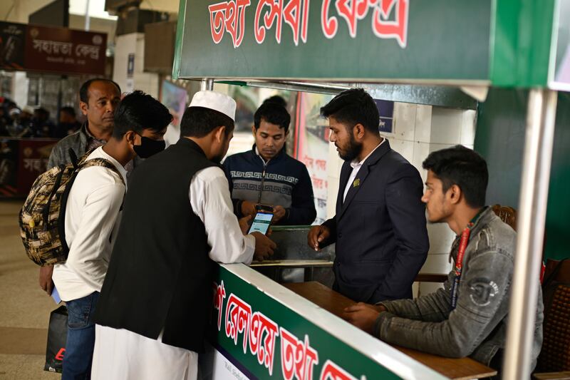 Stranded passengers make inquiries with a railway official amid the nationwide strike (Mahmud Hossain Opu/AP)