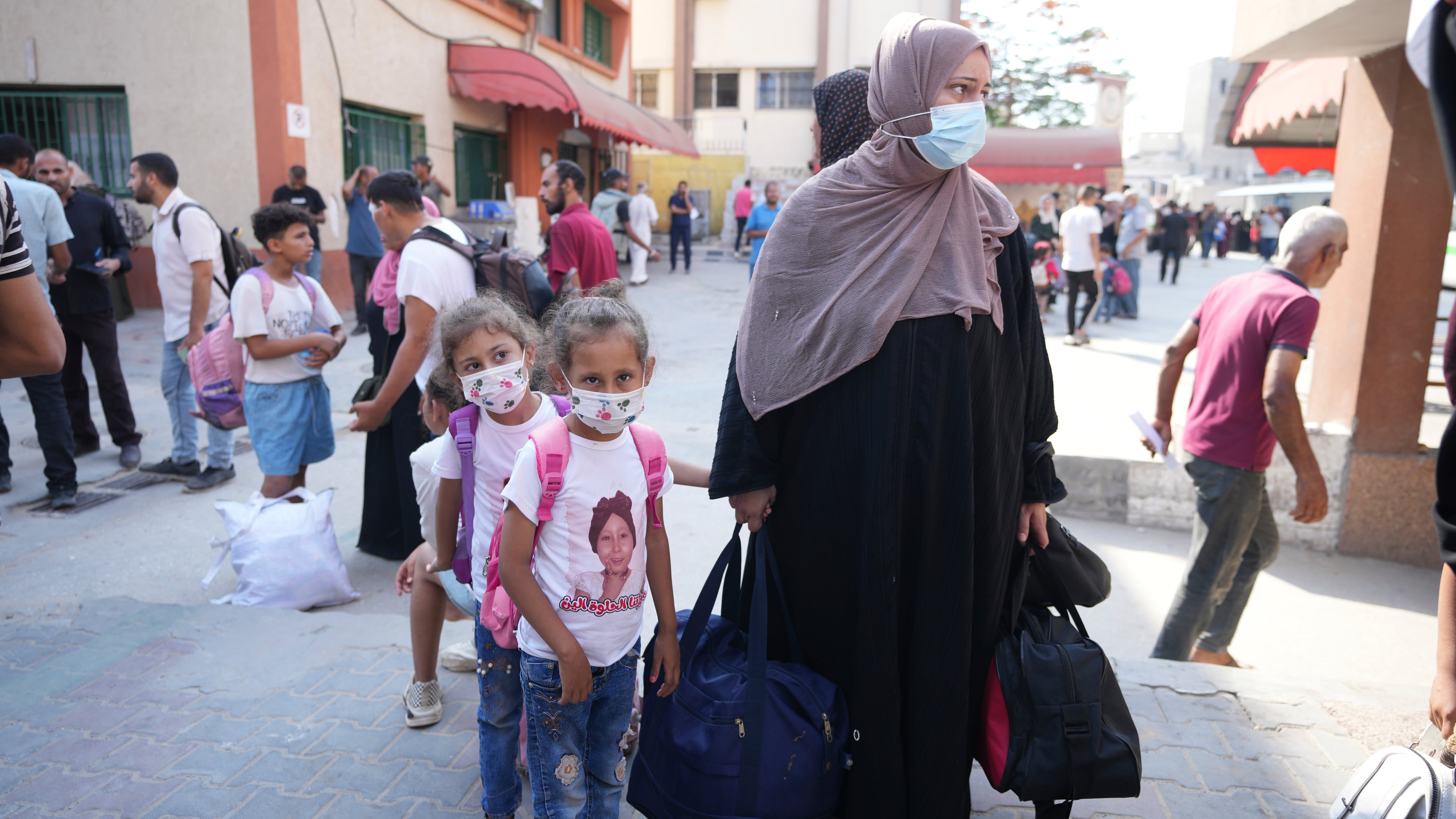 Palestinian children with chronic diseases stand next to their mother as they wait to leave the Gaza Strip (Abdel Kareem Hana/AP)