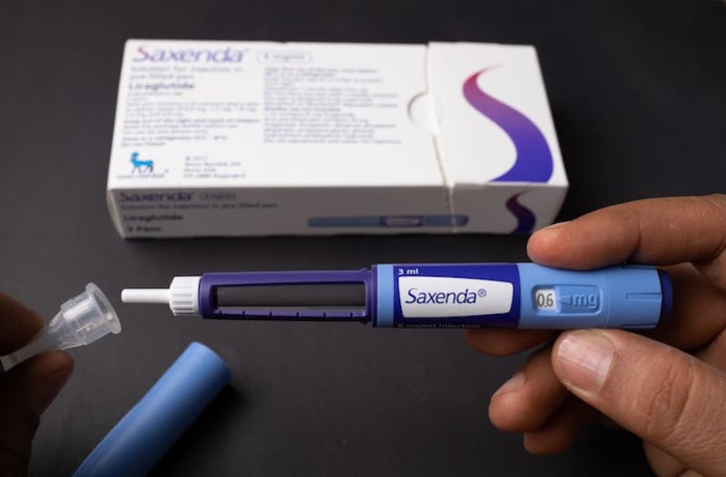 A person holds a prescription vial of Saxenda.