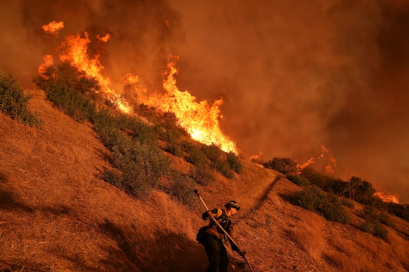 A firefighter battles the Palisades Fire in Mandeville Canyon (Jae C Hong/AP)