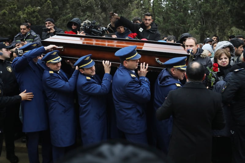 Pilots carry a coffin during a funeral of the crew members of the Azerbaijan Airlines plane (AP)