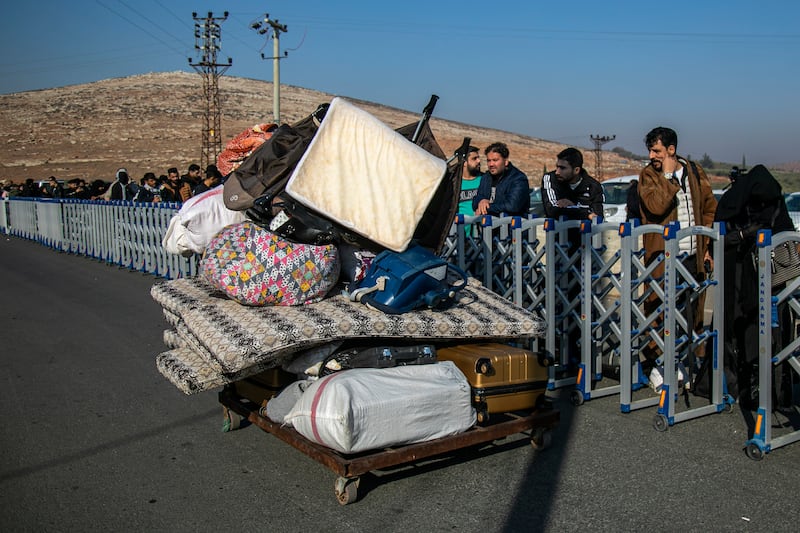 Syrians wait to cross into Syria from Turkey at the Cilvegozu border gate, near the town of Antakya, southern Turkey (Metin Yoksu/AP)