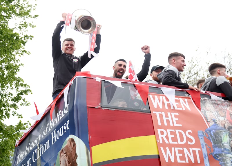 Cliftonville Players celebrate with the fans during an open top bus tour across Belfast after winning the Irish Cup oat Windsor on Saturday.
PIC COLM LENAGAN