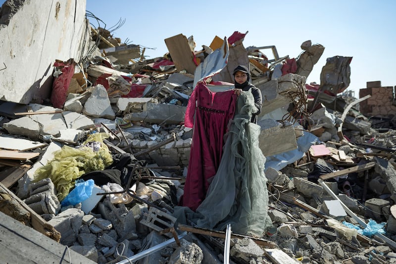 Nour Abu Al Zamar was among thousands of people trying to salvage items from under the rubble of her destroyed family home in Rafah (AP)