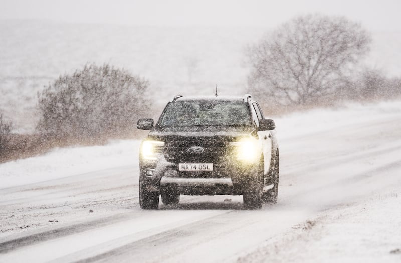 A car navigates snowy conditions on the A169 near Saltergate in North York Moors National Park