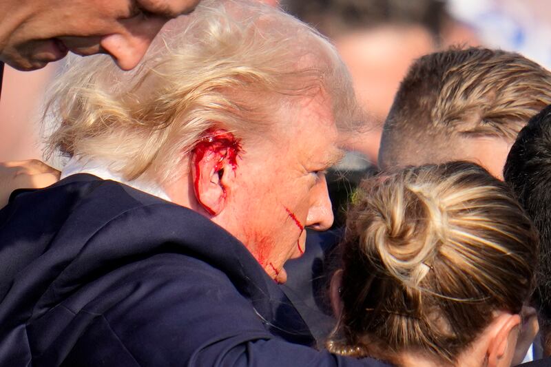 Former president Donald Trump is escorted to a motorcade following an attempted assassination at a campaign event (Gene J Puskar/AP)