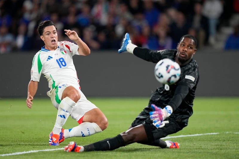 Giacomo Raspadori, left, pokes home Italy’s third goal (Michel Euler/AP)