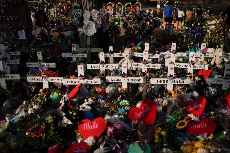 Flowers are piled around crosses with the names of the victims killed in a school shooting (Jae C Hong/AP)