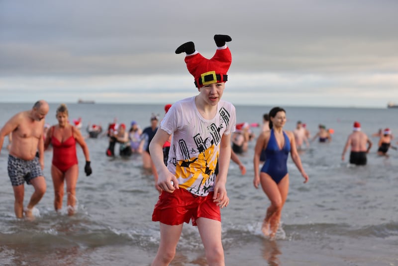 People take part in the annual Christmas Eve swim at Helen’s Bay